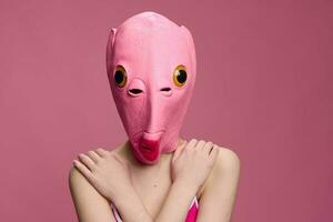 Conceptual art photo of a sexy woman in a fish mask for Halloween on a pink background