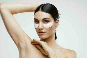 woman with bare shoulders patches near eyes cosmetics photo