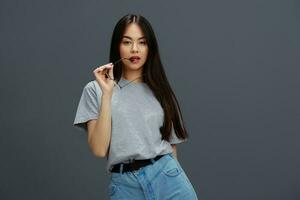 young woman with long hair in a gray T-shirt gesturing with hands isolated background photo