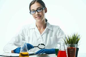 woman biologist white coat sitting at the table research plant photo