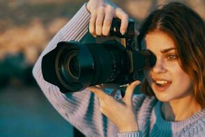 woman with camera in nature taking pictures of landscape Professional photo