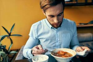 man eating lunch in a restaurant hot broth food break at work photo
