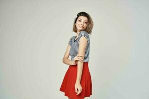 bonito mujer en un a rayas camiseta rojo falda moderno estilo peinado foto