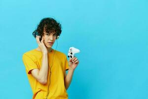 man in headphones plays games gamepad blue background photo