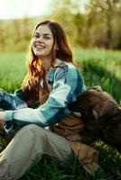 Woman on the grass with her dog in the park in the evening with sunshine smiling photo