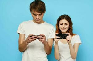young couple in white t-shirts with phones in hands technology photo