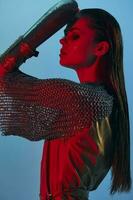 young woman red light silver armor chain mail fashion blue background photo