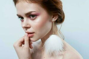 attractive woman bare shoulders fluffy earrings cosmetics close-up photo