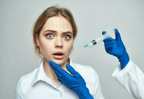 mujer jeringuilla anestesia botox inyección médico azul guantes foto