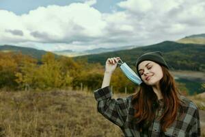 Happy woman in the forest with a medical mask on her face photo