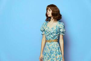 Woman in fashionable dress looking away blue background short hair photo