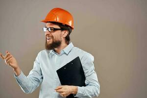 emotional worker man in orange paint documents service construction beige background photo