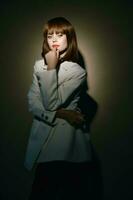 model in light coat gesticulate with hands studio photo