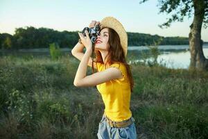 Woman photographer with camera looks into the camera nature trees summer photo