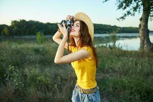 mujer fotógrafo con cámara mira dentro el cámara naturaleza arboles verano foto