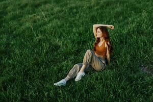 Woman sitting on green grass in nature in a park, view from above photo