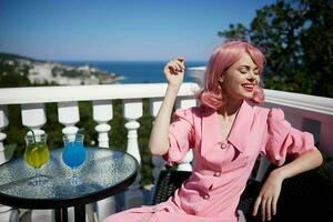 Delighted young girl drinking a cocktail on the terrace Relaxation concept photo