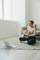Woman exercising at home by video workout online, meditation and stretching, mental health photo