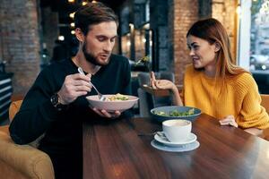 young couple sitting at the table eating healthy lifestyle communication photo