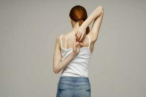 woman in white t-shirt back pain health problems osteoporosis studio treatment photo