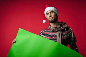 emotional man in a christmas hat with green mockup studio posing photo