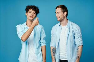 Happy friends in identical shirts chatting on a blue background fun model photo