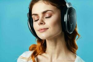 woman with headphones listening to music entertainment technology fashion blue background photo