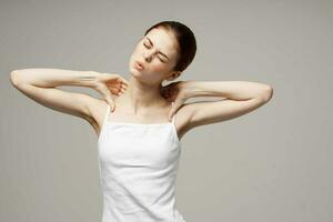 mujer en blanco camiseta participación en a el cuello salud problemas articulación estudio tratamiento foto
