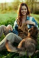Woman on the grass with her dog in the park in the evening with sunshine smiling photo
