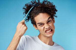 problems with combing hair young guy in t-shirt and combing curls model photo