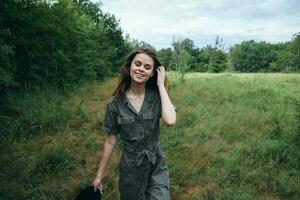 woman outdoors In green jumpsuit with closed eyes smile landscape fresh air photo