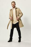 guy in a beige coat with a belt in his hand and black pants sweater model photo