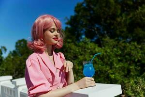 portrait of beautiful woman in pink dress outdoors with cocktail Relaxation concept photo