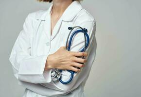Woman in white coat doctor and stethoscope in hand photo