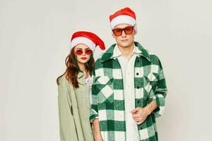 A man and a woman stand side by side in sunglasses Christmas holiday New Year hats friendship photo