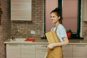 un ama de casa en un delantal en el cocina corte tablero con cuchillo tareas del hogar casa concepto foto