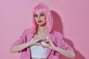 Young positive woman hold hands in the shape of a heart with a pink jacket monochrome shot photo