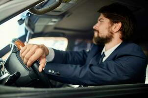 bearded man in a suit in a car a trip to work success service rich photo