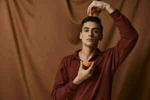 Man with oranges over his head studio fabric background photo