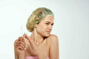 woman with bare shoulders pimples on her forehead cleaning face photo