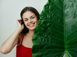 smiling woman in red swimsuit green palm leaf charm photo