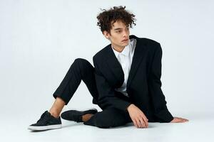 Cheerful guy curly hair suit fashion modern style studio photo