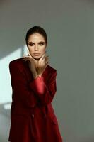 mujer participación manos cerca cara encanto productos cosméticos rojo chaqueta modelo foto