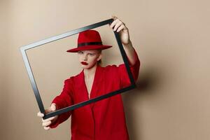 retrato de un mujer marco en mano en rojo sombrero y chaqueta estilo de vida posando foto