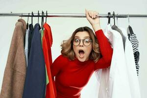 pretty woman with glasses next to clothes fashion fun light background photo