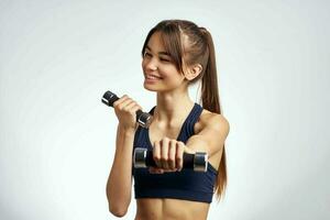 sports brunette with dumbbells in hands workout fitness exercise photo