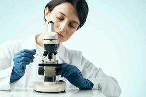 mujer en blanco Saco microscopio investigación diagnósticos profesionales foto