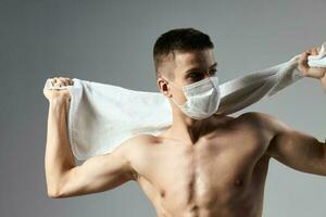 deporte hombre vistiendo médico máscara blanco toalla en manos salud la seguridad rutina de ejercicio de cerca foto