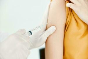 a doctor injects a covid-19 vaccine into a woman's shoulder photo