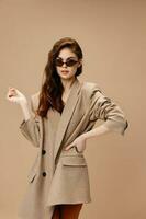 romantic woman in a coat on a beige background glasses on the face photo